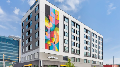 Street view of the cambria hotel, colorful mural on the front.
